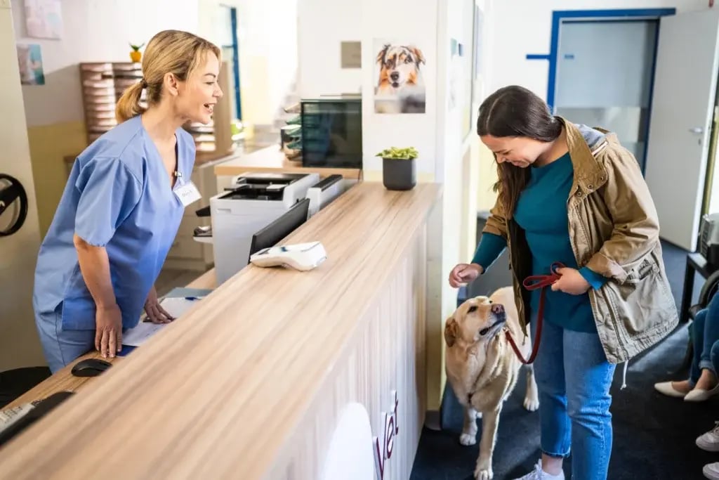 Pet owner and veterinary staff in a welcoming clinic environment—echoing the safer, low-odor spaces BioBond coatings help support